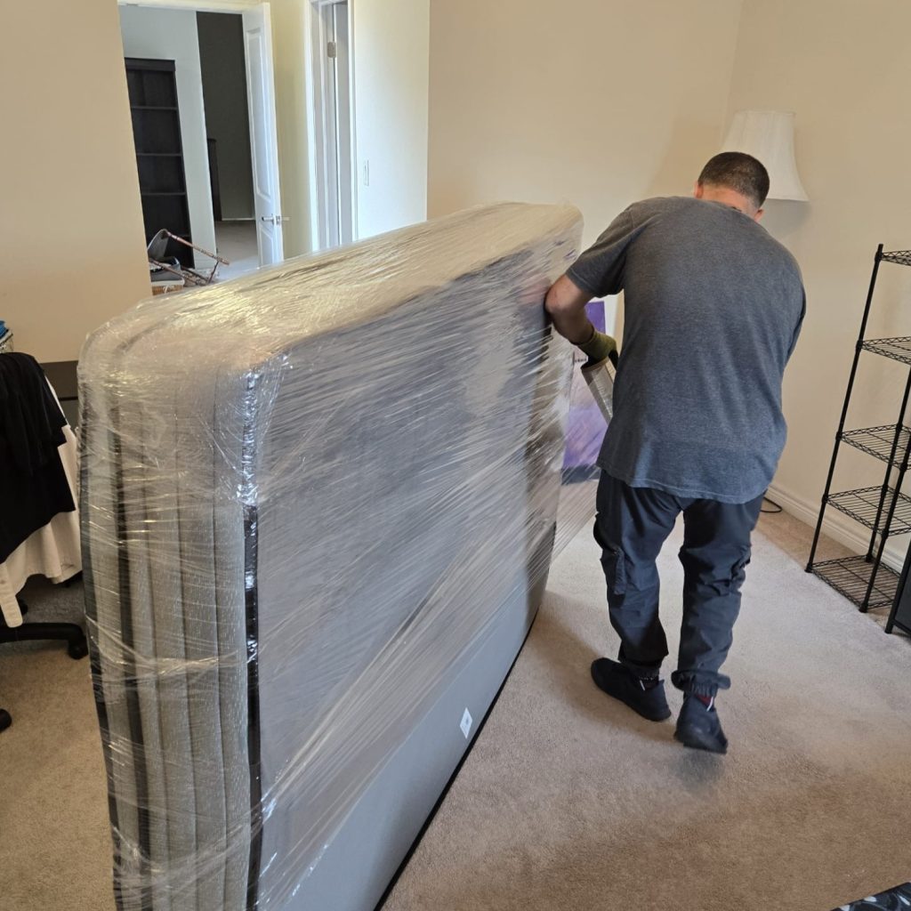 man wrapping mattress for moving