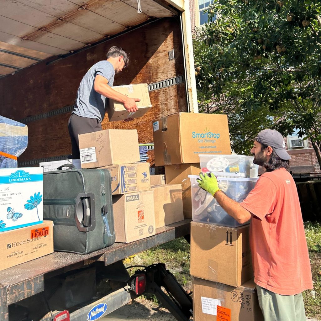 movers packing boxes into truck for downsizing