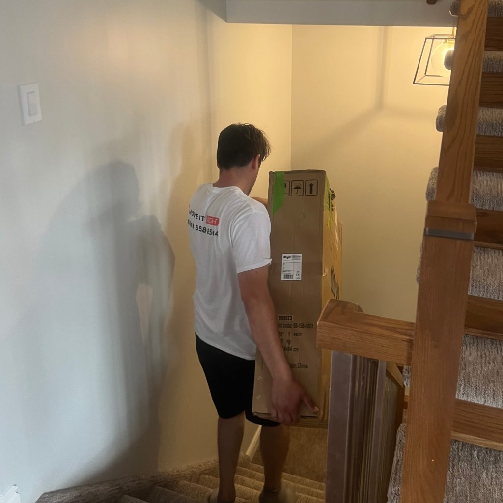 mover taking packed furniture down the stairs