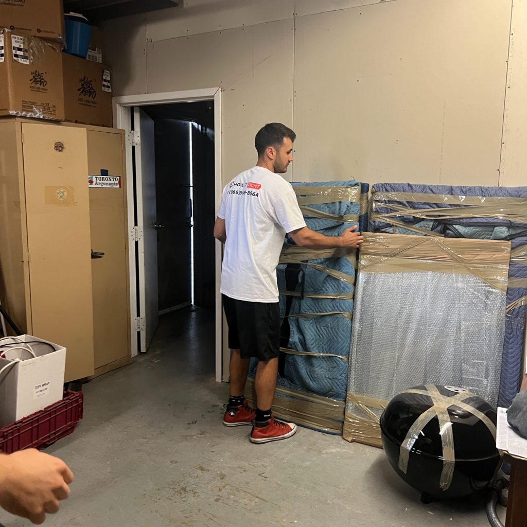 mover wrapping furniture in garage