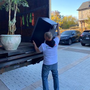 mover putting fridge in a truck