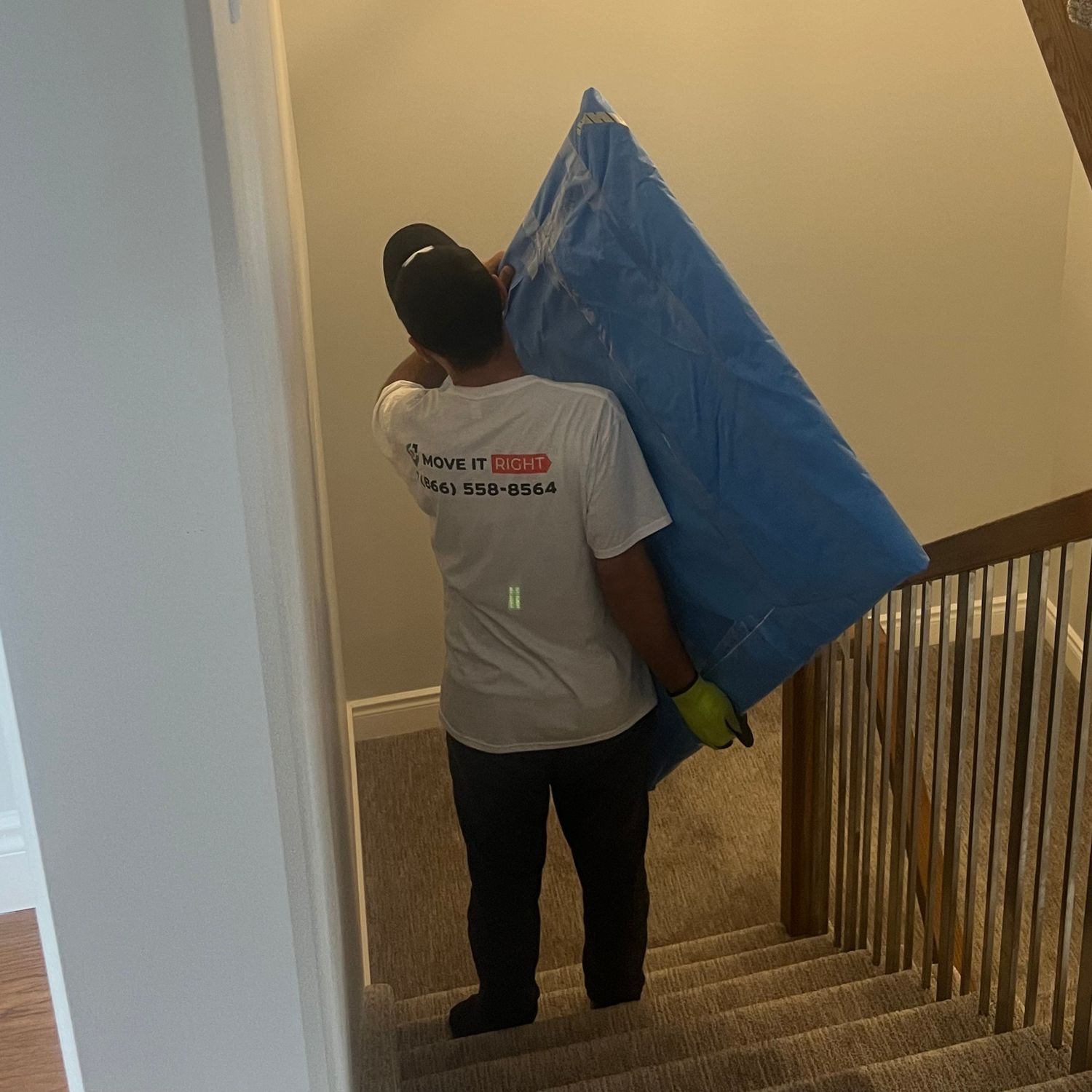 mover taking big furniture down staircase
