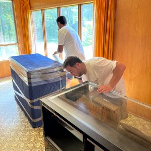 movers disassembling furniture in new home