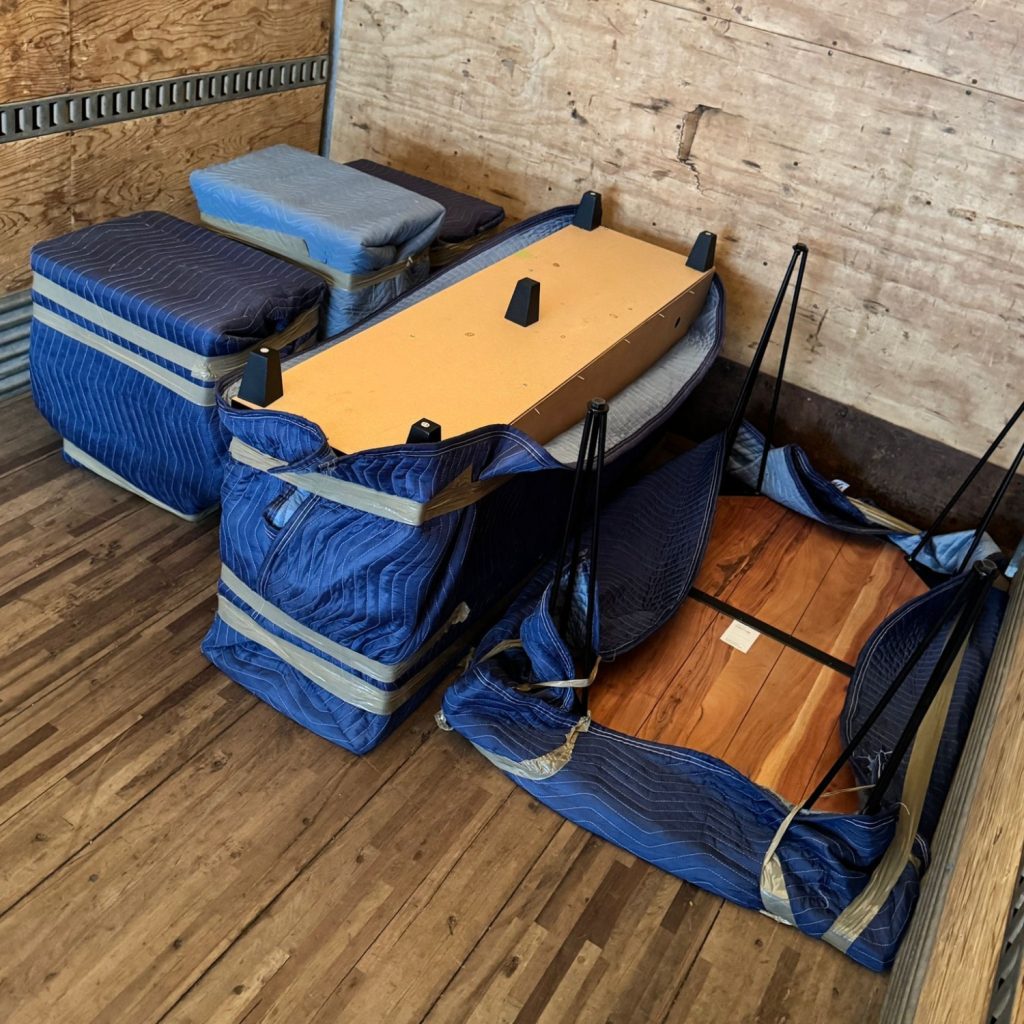 office decks wrapped in padding in moving truck