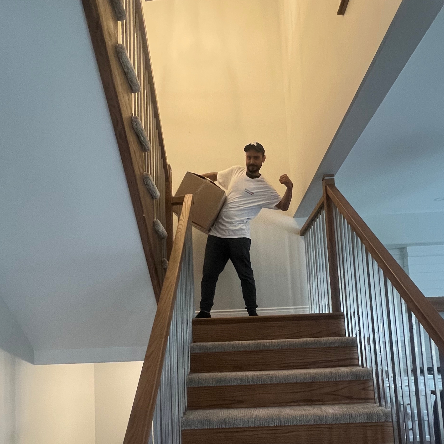 mover posing with muscles on top of staircase