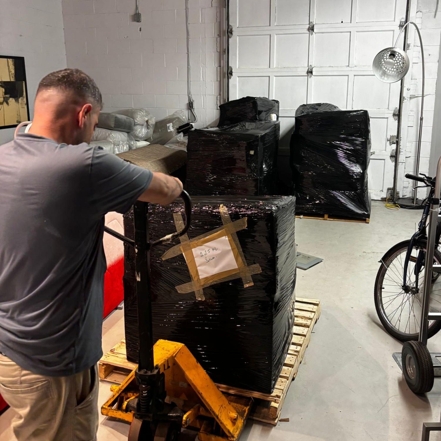 mover taking furniture out of warehouse on a trolley and pallet
