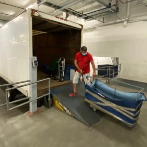 mover taking warehouse equipment into a moving truck