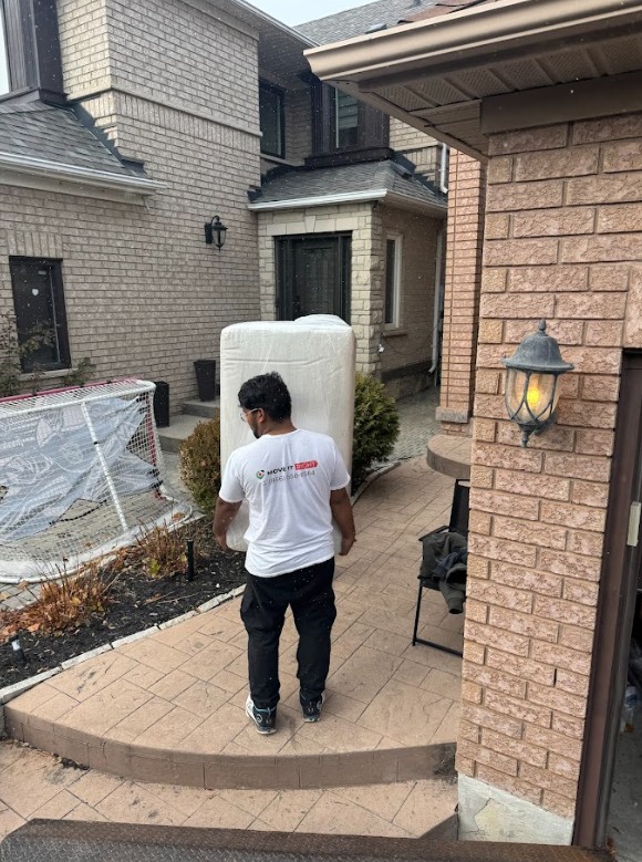Move It Right mover carrying mattress into a GTA home during a spring move